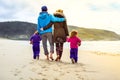 Happy young family is walking on sandy beach and ocean Royalty Free Stock Photo